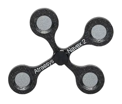 A black four-armed fidget spinner with metallic circular weights at each end, labeled Atracsys and Navex 2 on two of the arms.
