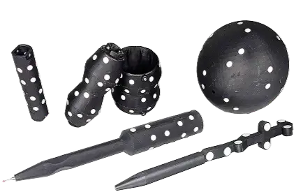 Black juggling equipment with white polka dots, including clubs, balls, and batons, arranged on a flat surface.
